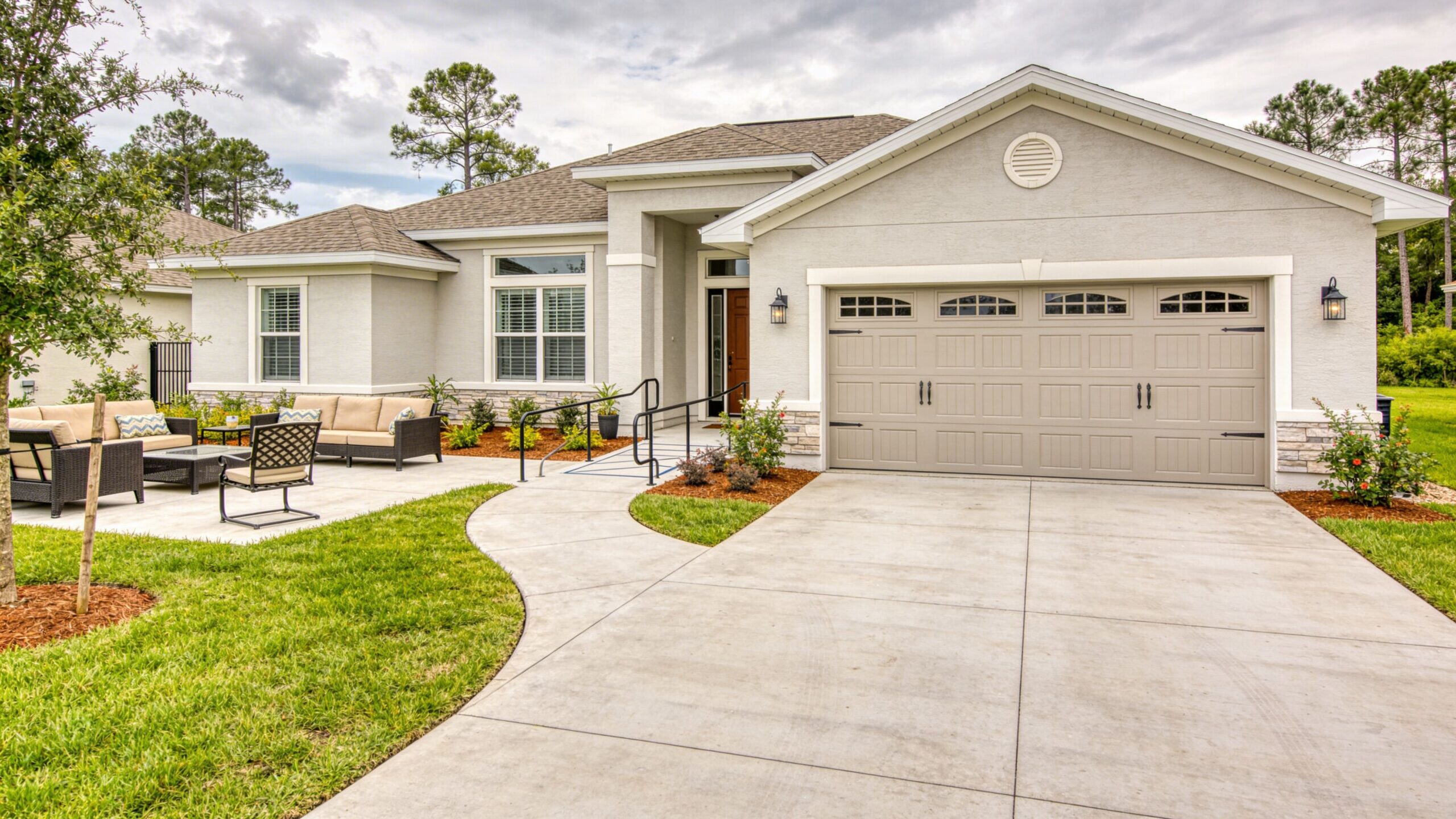 A modern single-family home with a concrete driveway, landscaped yard, and patio area in Ocala, Florida.