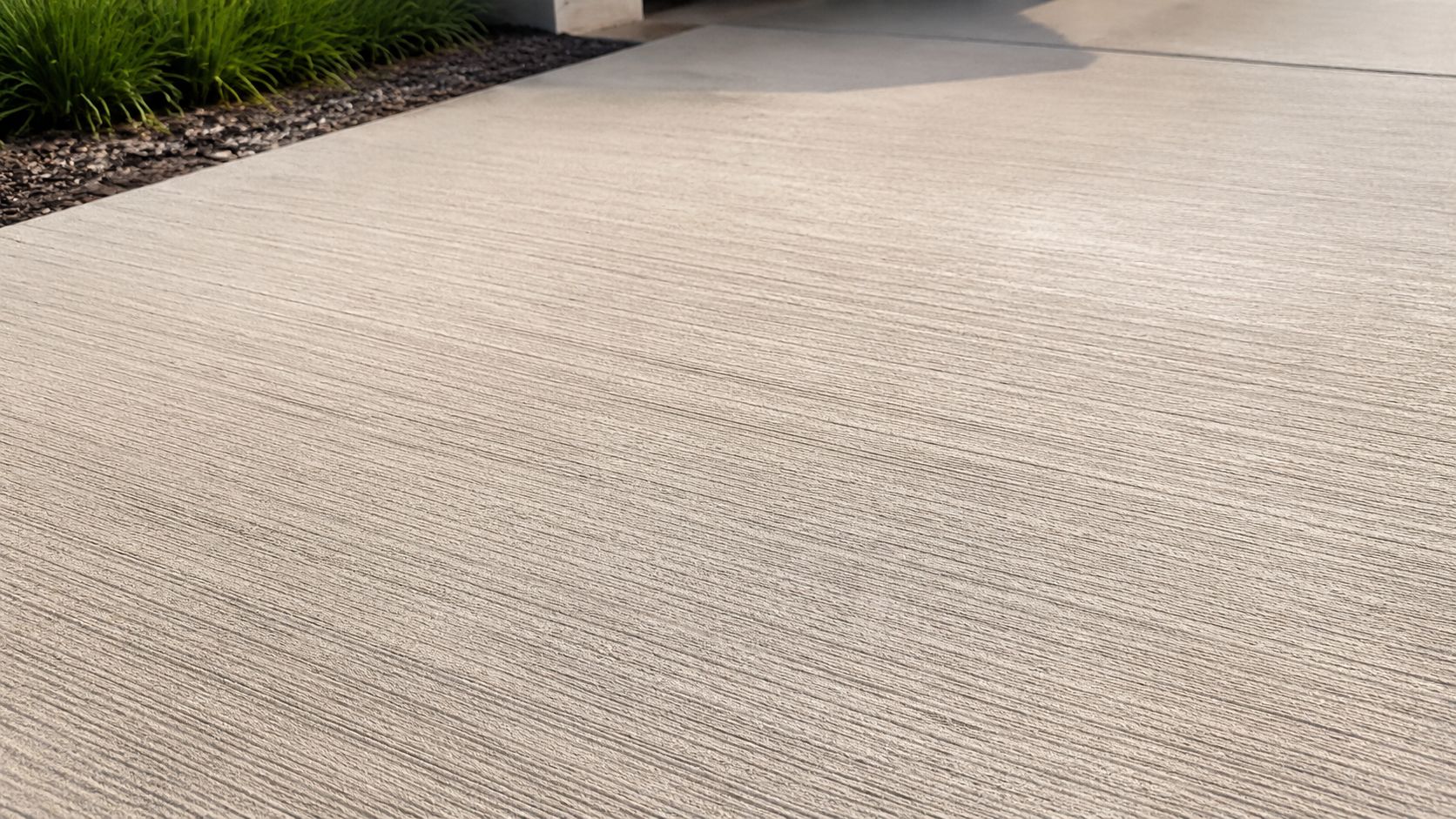 A close-up view showing the textured, brushed concrete finish of a modern outdoor patio or driveway.